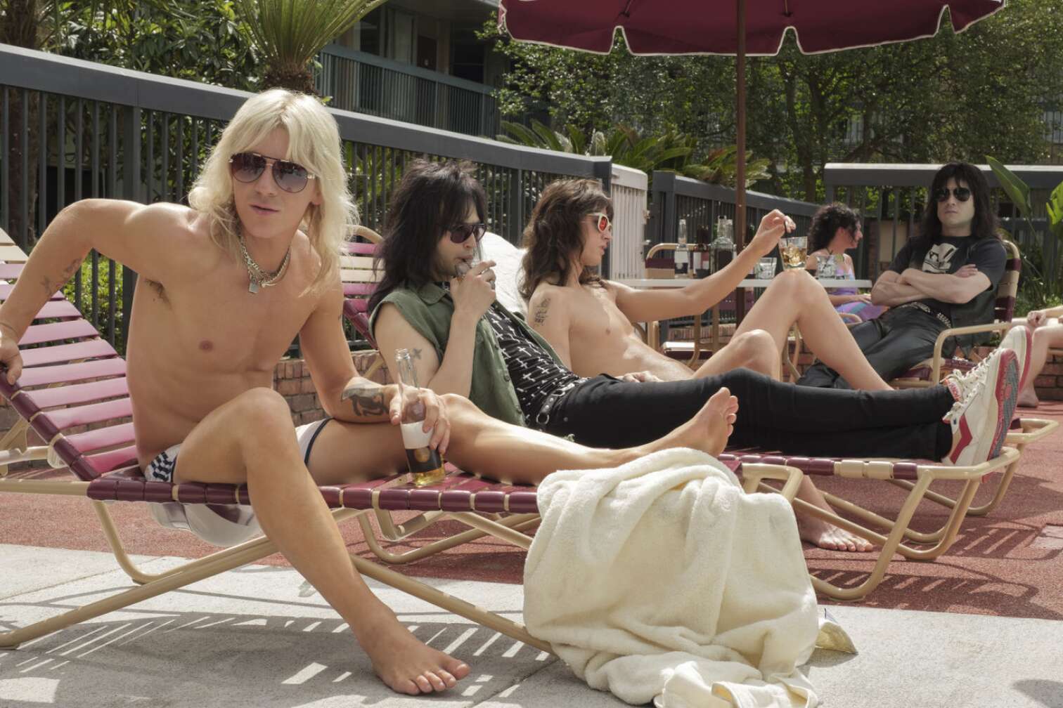 Die Mitglieder von Mötley Crüe liegen an einem Pool