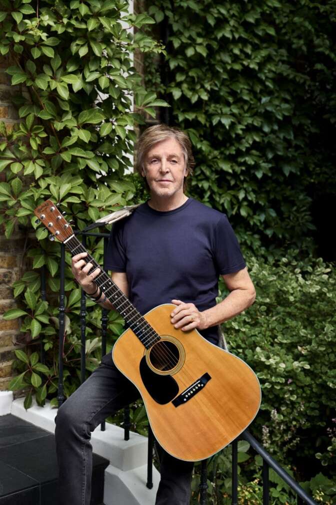 Paul McCartney posiert mit einet Gitarre