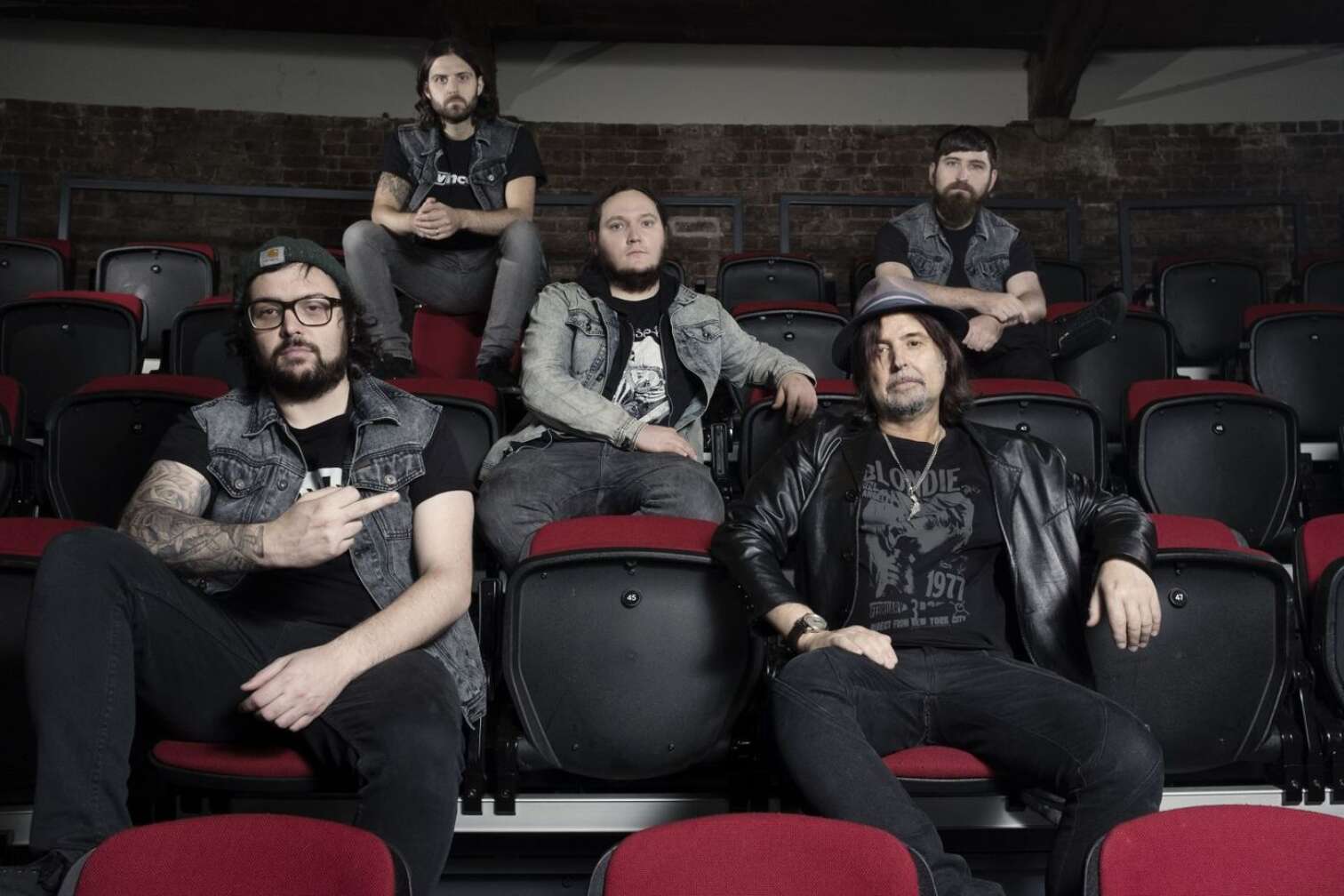 Phil Campbell sitzt mit Musikerkollegen auf Kinositzen