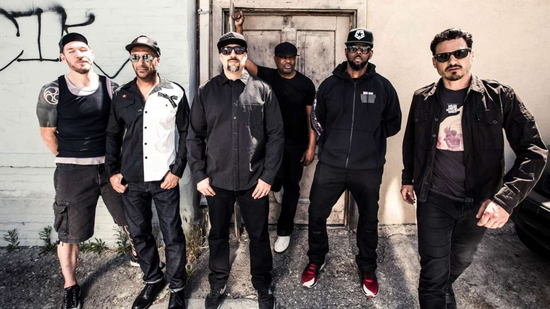 Prophets of Rage posieren vor einem Hauseingang