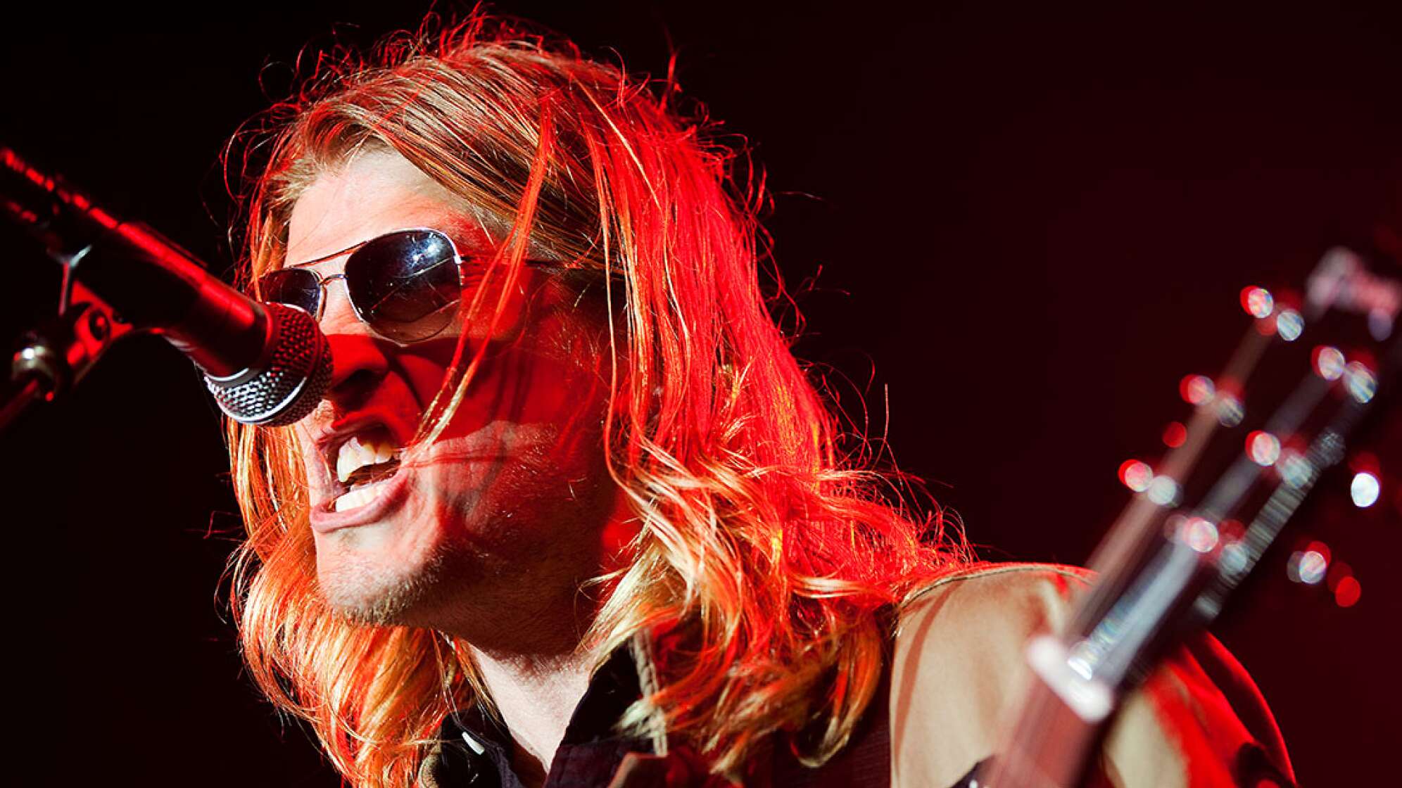 Wes Scantlin trägt eine Sonnenbrille und singt in ein Mikrofon