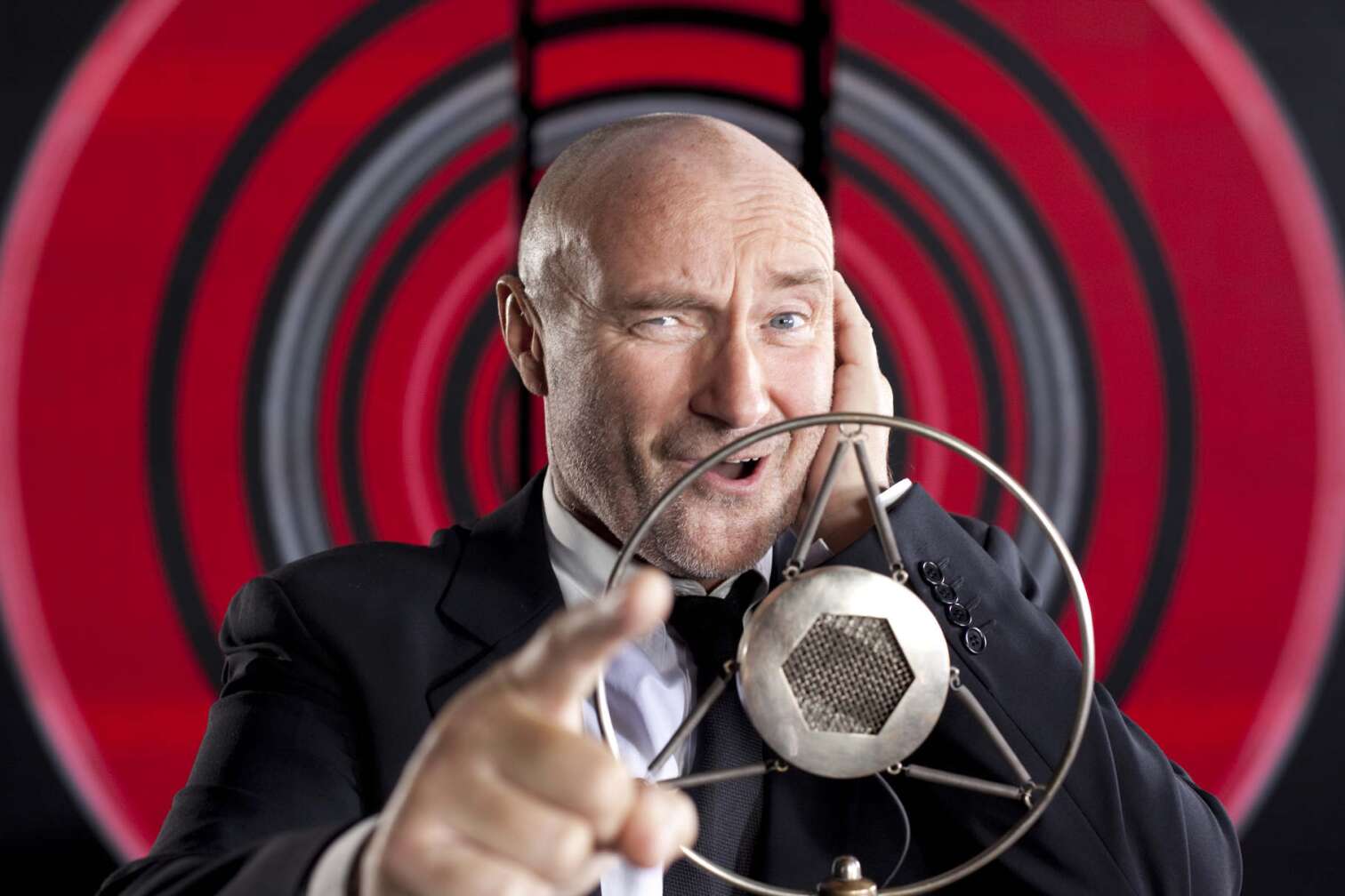 Phil Collins im Porträt vor antikem Gesangs-Mikrofon