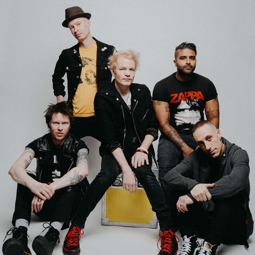 Bandmitglieder von Sum 41 vor weißem Hintergrund