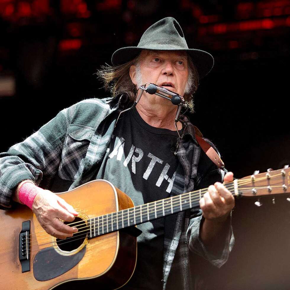 Neil Young mit Gitarre auf der Bühne