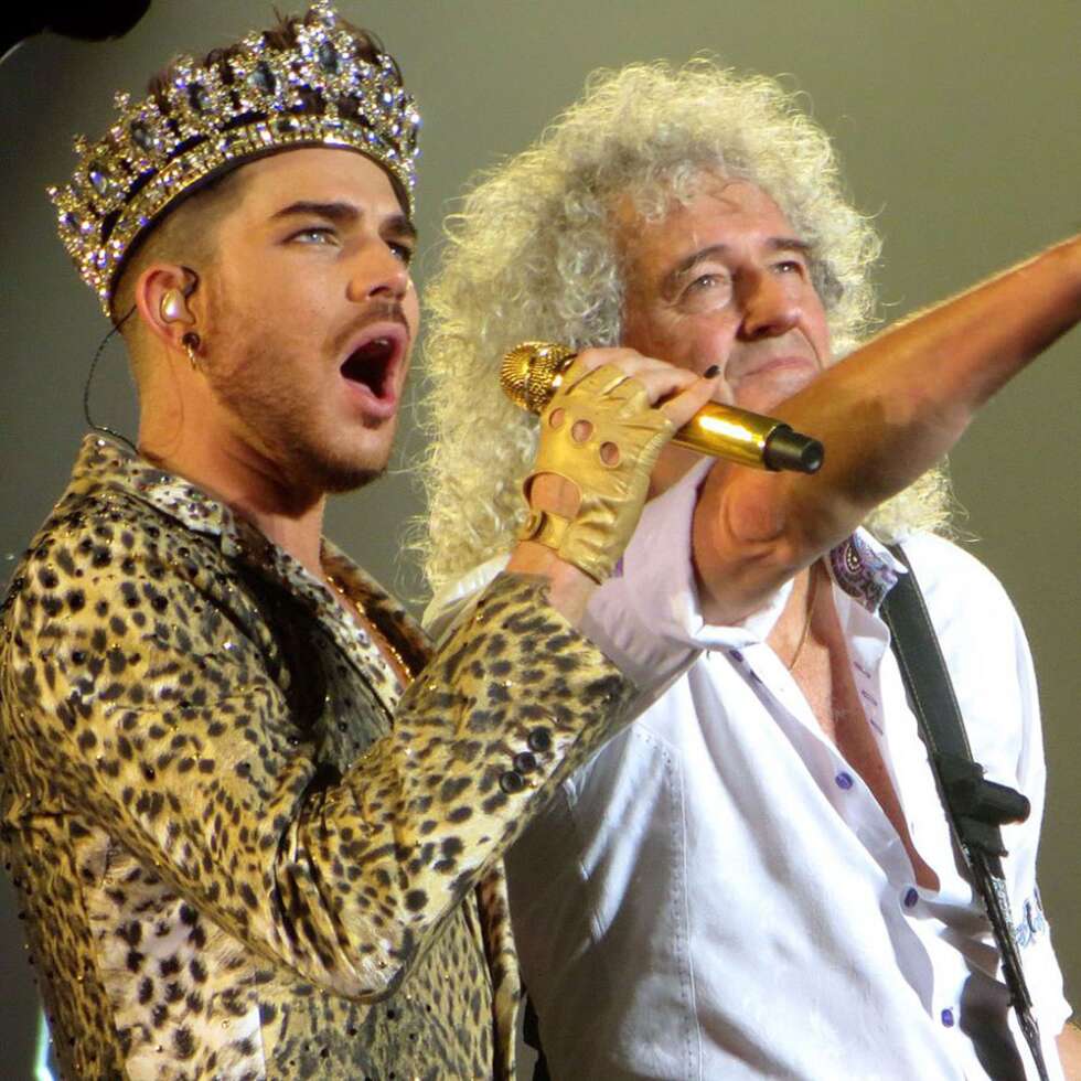 Adam Lambert mit Krone und Leo-Mantel, gemeinsam mit Brian May auf der Bühne