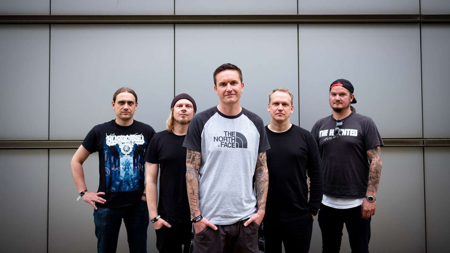 Mitglieder von "Heaven Thall Burn" posieren nebeneinander vor einer Wand