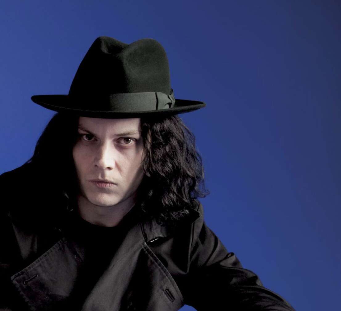 Jack White mit einem Hut vor blauem Hintergrund