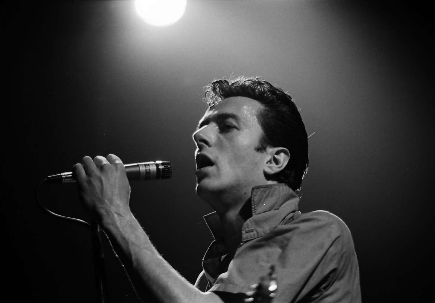Joe Strummer singt in ein Mikrofon