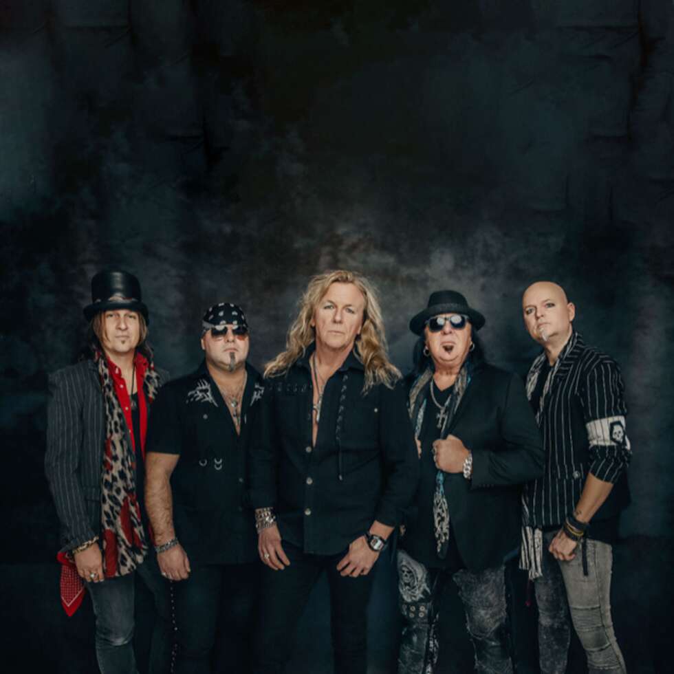 Bandmitglieder der Pretty Maids vor rauchschwarzem Hintergrund
