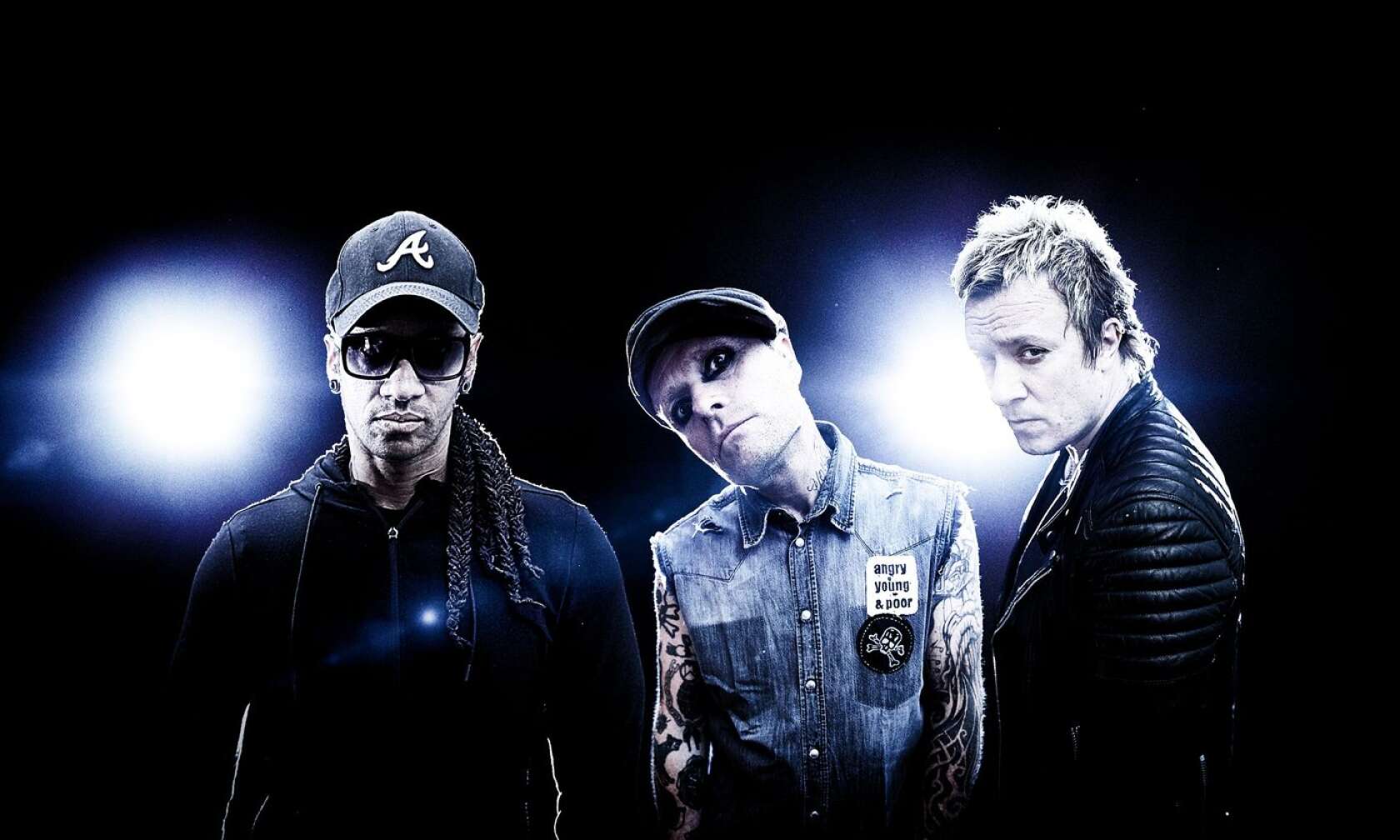 The Prodigy posieren vor zwei Scheinwerfern