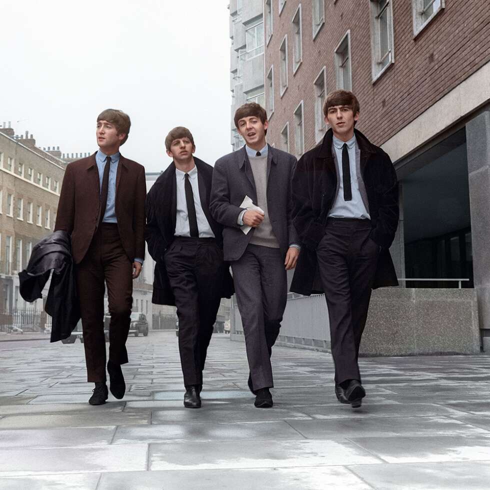 Die Mitglieder der Beatles laufen eine Straße entlang