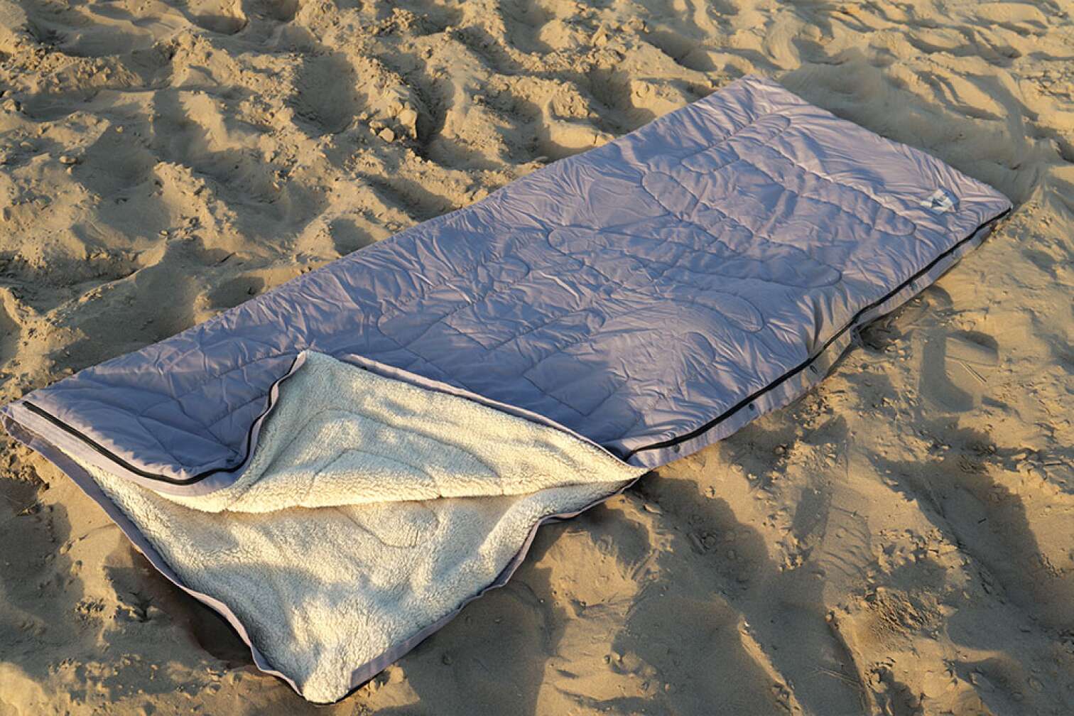 Bent Bentcho Schlafsack ausgerollt auf einem Strand