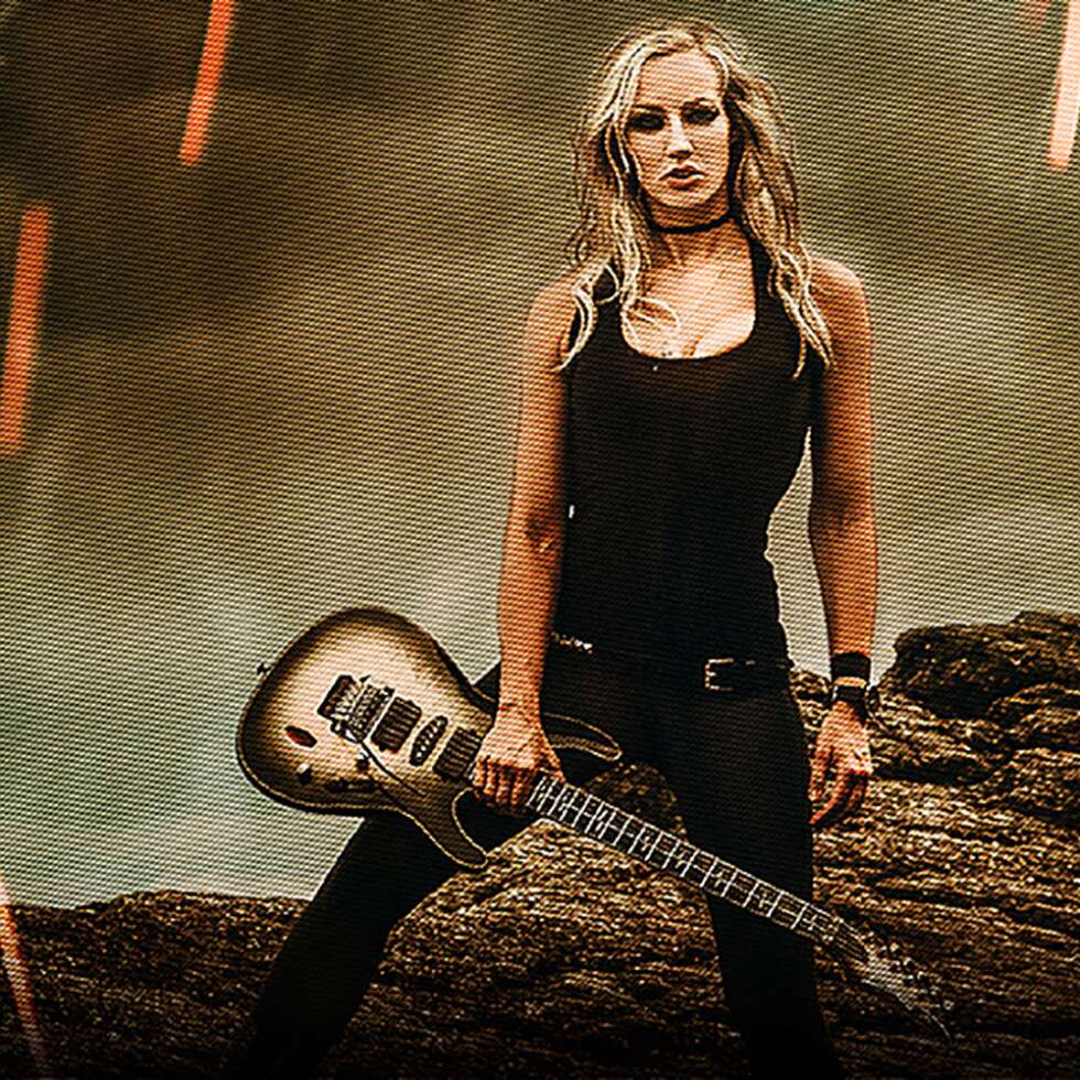 Nita Strauss mit einer Gitarre in der Hand