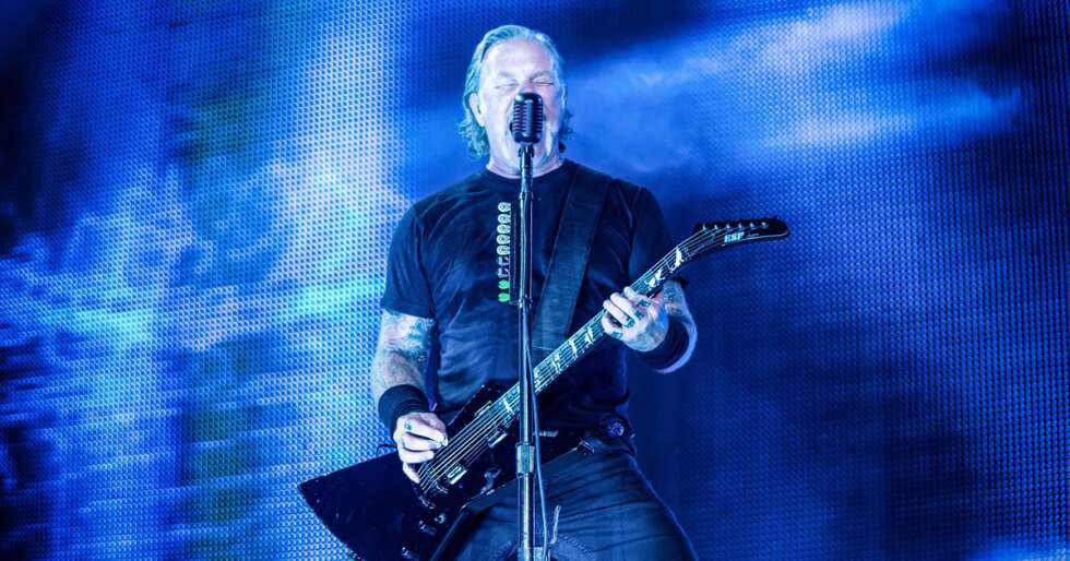 James Hetfield spielt Gitarre und singt auf einer Bühne bei einer Live-Show