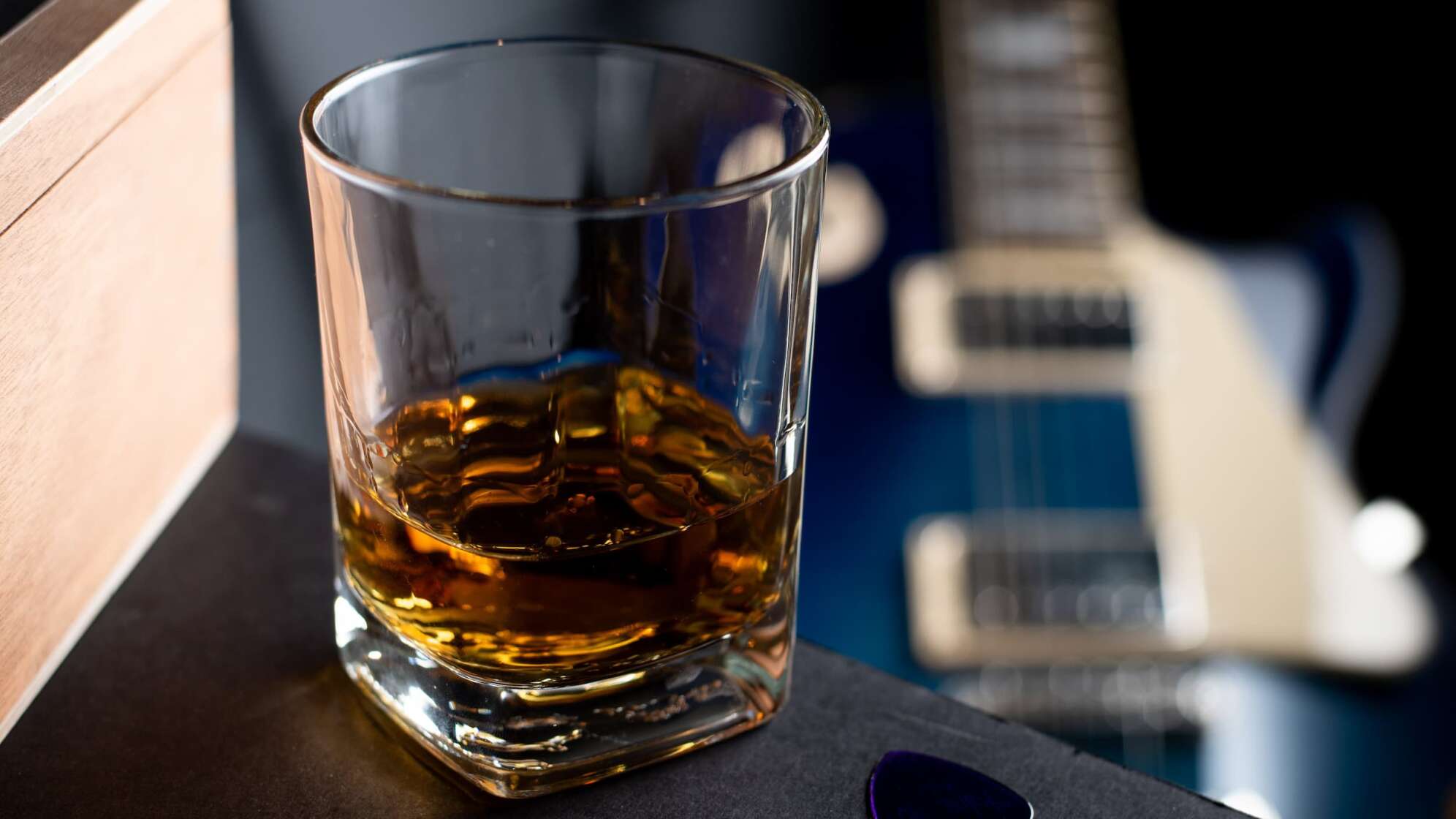 Whiskey-Glas mit Gitarre im Hintergrund