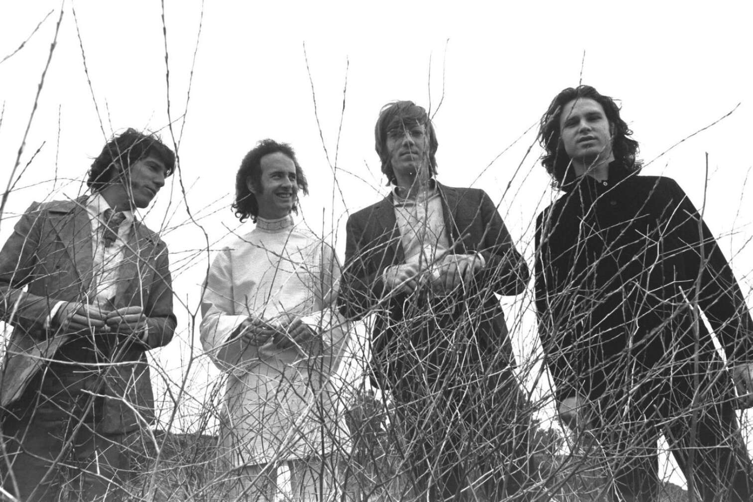 The Doors posieren vor einem Strauch