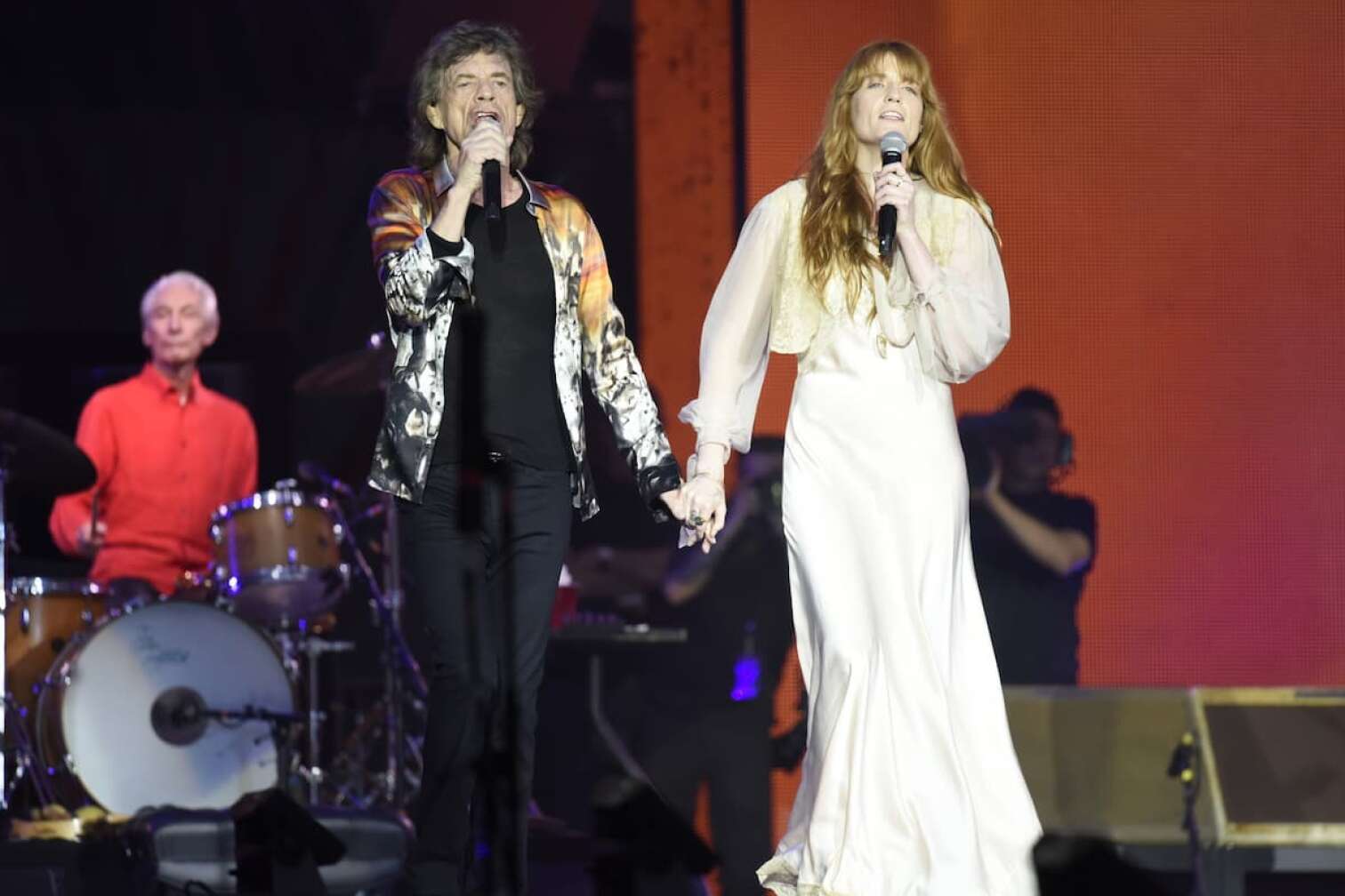 Mick Jagger mit Frau im weißem Kleid auf der Bühne