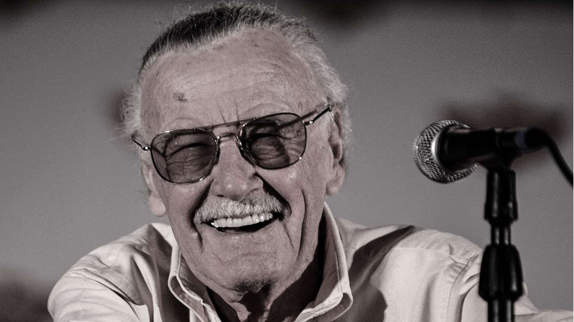 Stan Lee mit Sonnenbrille, lächelnd im Porträt