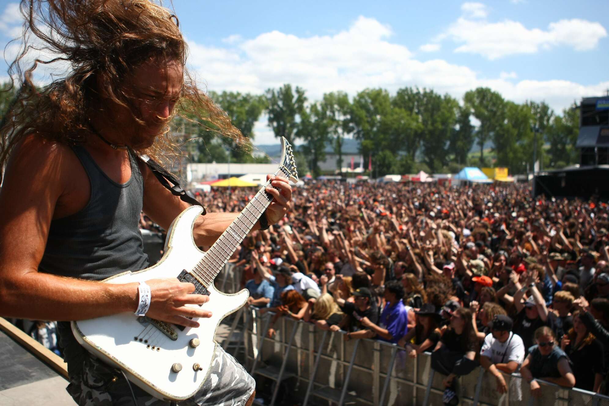 Gitarrist auf der Bühne beim Bang Your Head Festival 2008 mit Menschen im Hintergrund