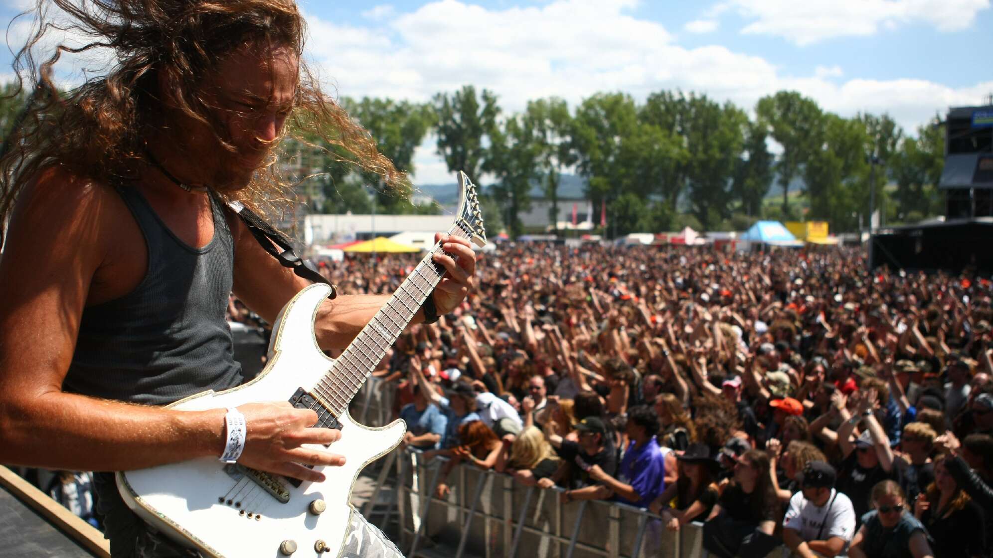 Gitarrist auf der Bühne beim Bang Your Head Festival 2008 mit Menschen im Hintergrund