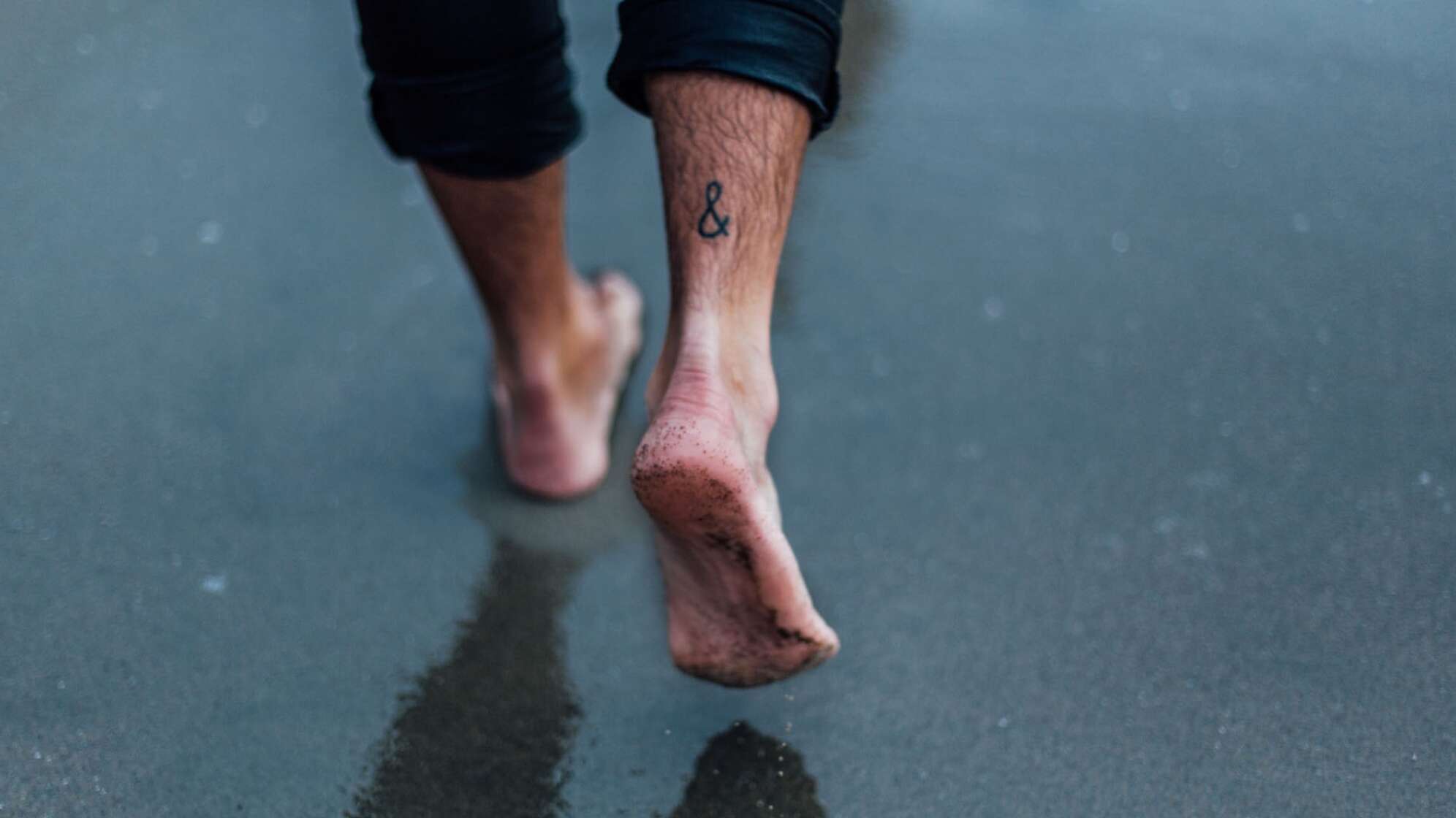 Eine Nahaufnahme von Männerfüßen barfuß am Strand