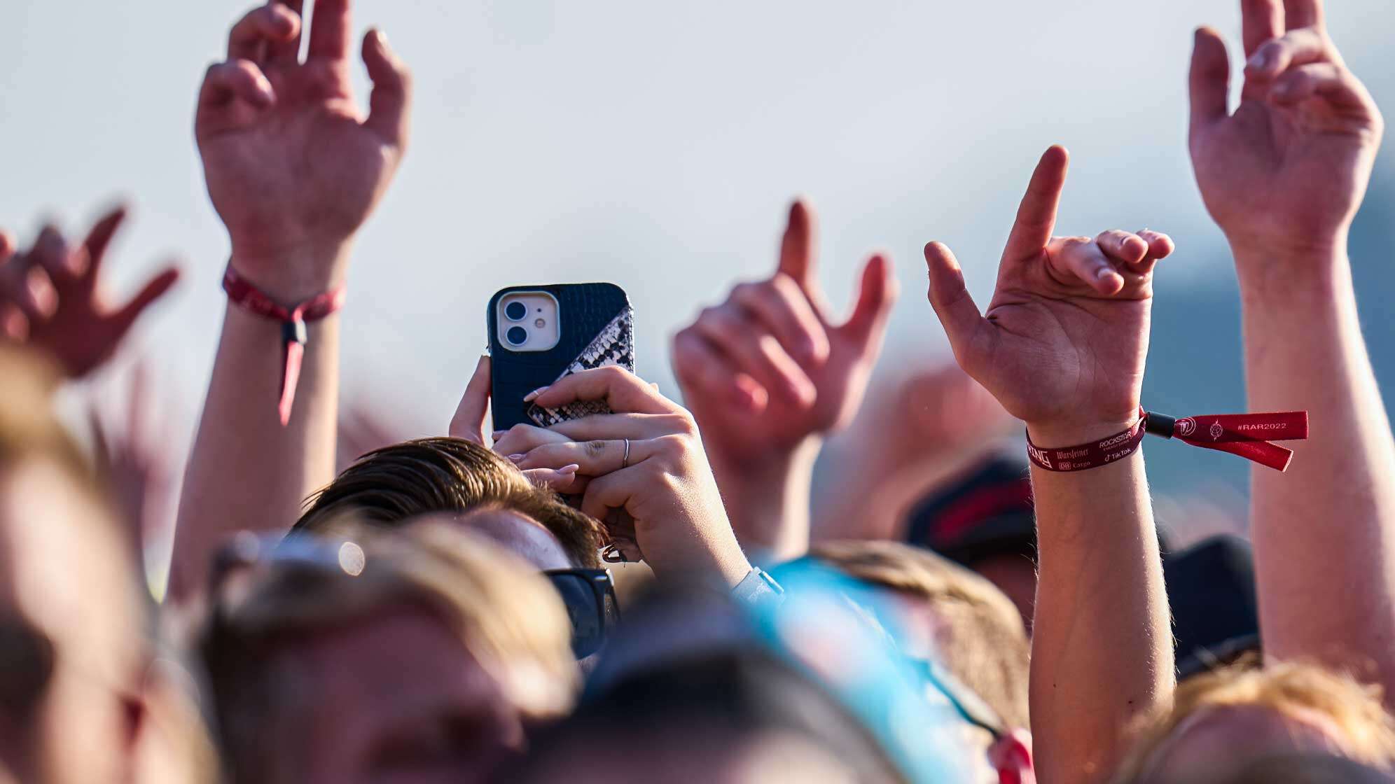 Konzertbesucher beim Festival Rock am Ring - eine Person hält ein Smartphone in die Luft.