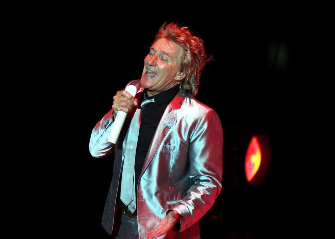 Rod Stewart singt mit silbernem Sakko auf der Bühne