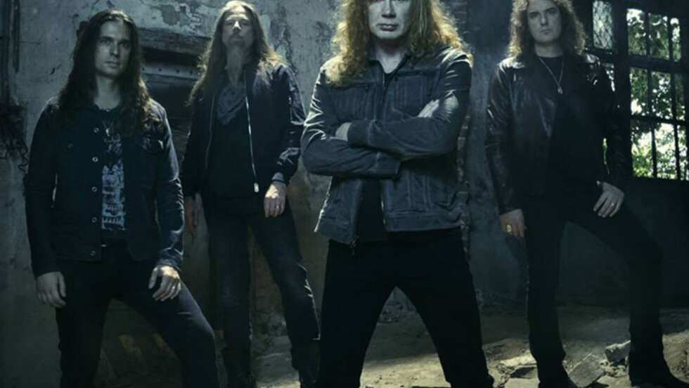 Die Band Megadeth steht in einer dunklen Halle und schaut ernst