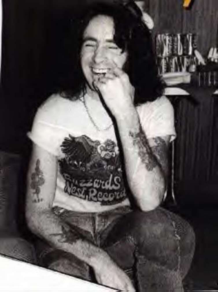 Bon Scott von AC/DC sitzend, lächelnd