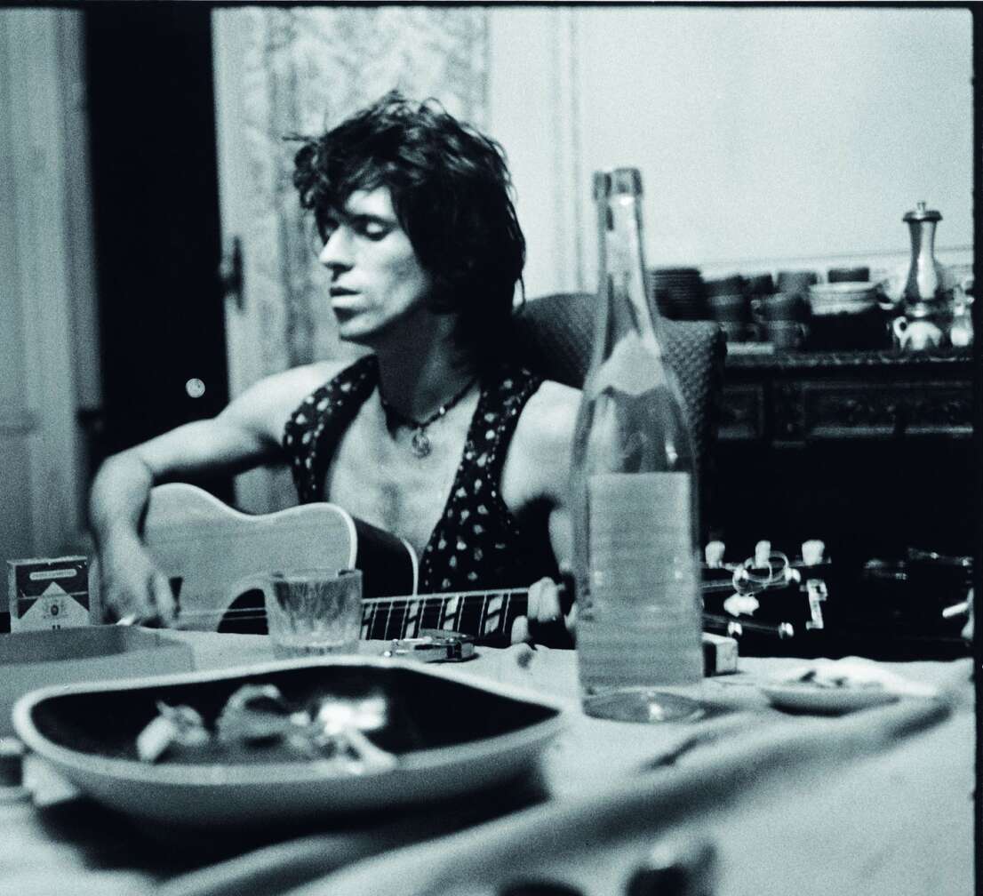 Keith Richards sitzt Backstage mit Gitarre, leerer Flasche und Aschenbecher
