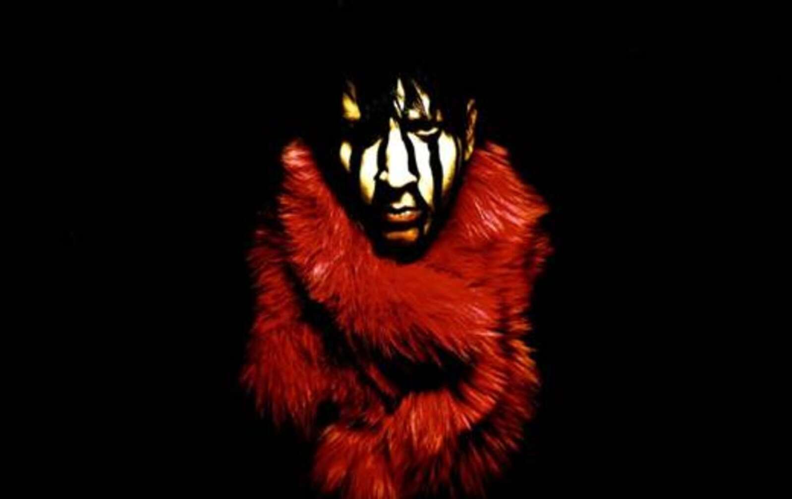 Marilyn Manson starrend, mit rotem Fellkragen