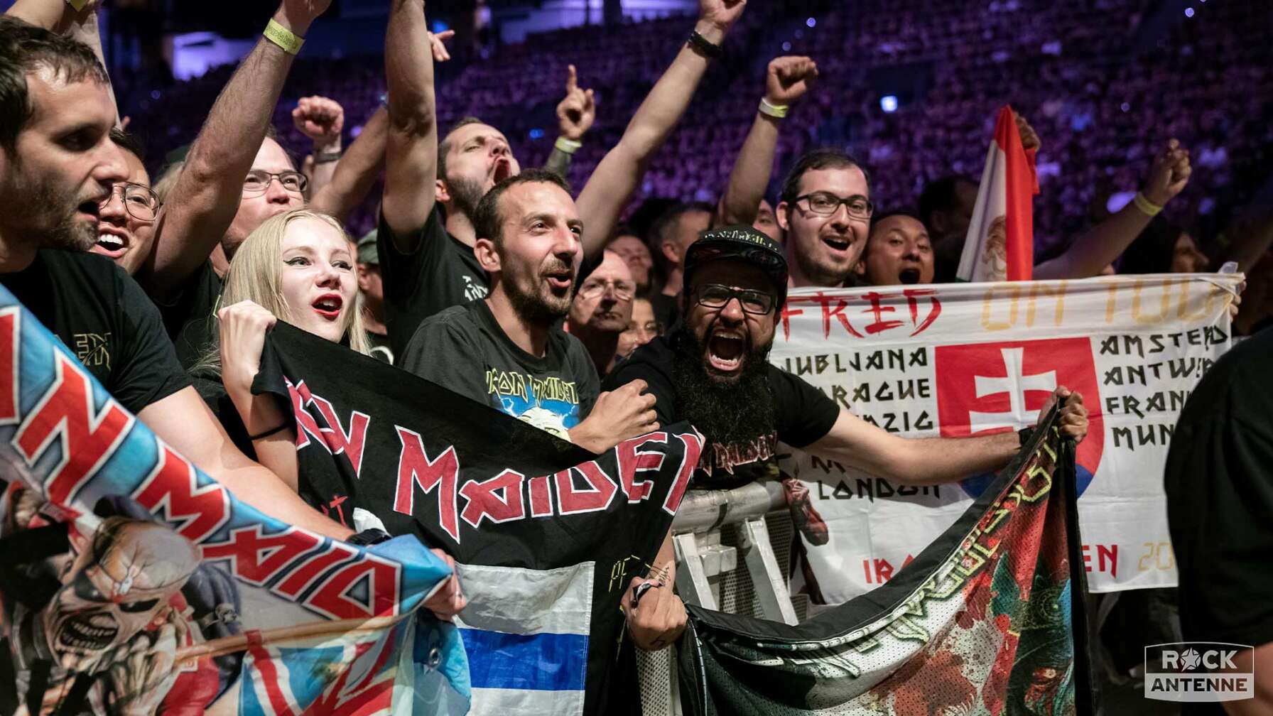 Die Fans von Iron Maiden kurz vor dem Konzert - sie halten Flaggen und Fahnen in den Händen