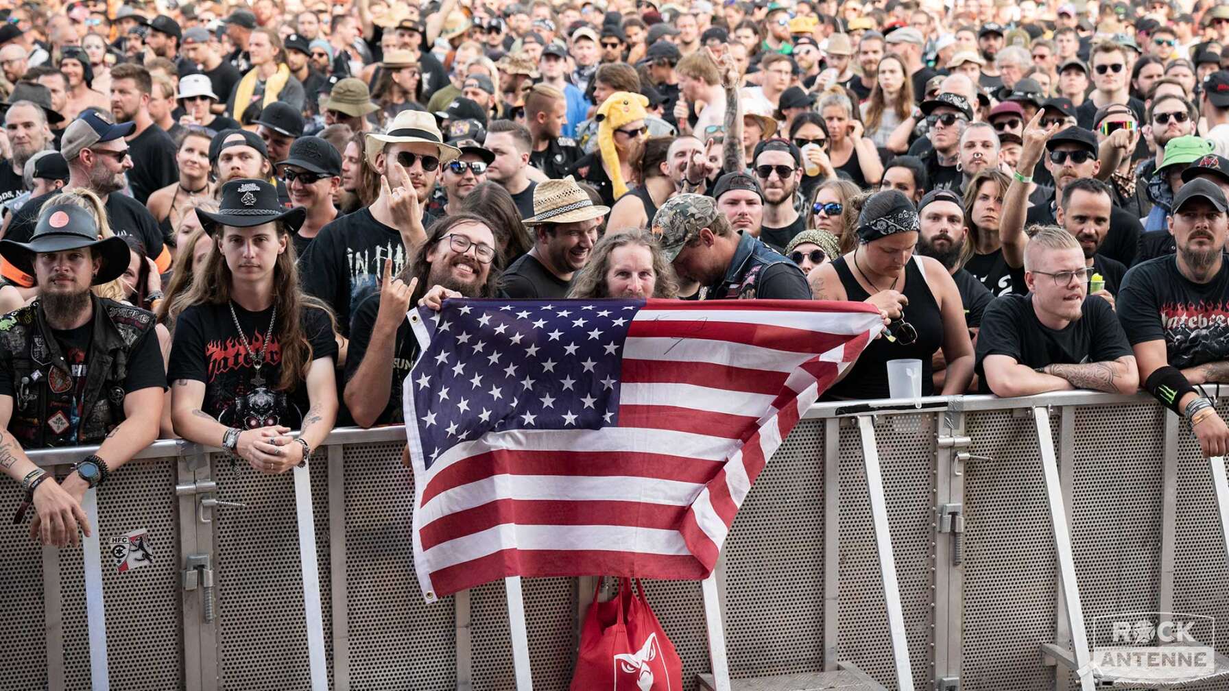 Das Publikum vor der Bühne des Summer Breeze Open Airs - zwei Fans halten eine USA-Flagge in die Kamera.