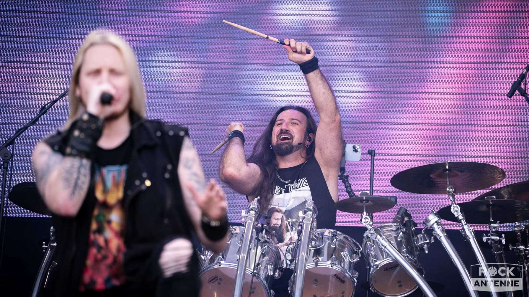 Der Schlagzeuger der Band Dragonforce auf der Bühne des Summer Breeze Open Airs. Vor ihm sieht man leicht verschwommen den Sänger der Band.