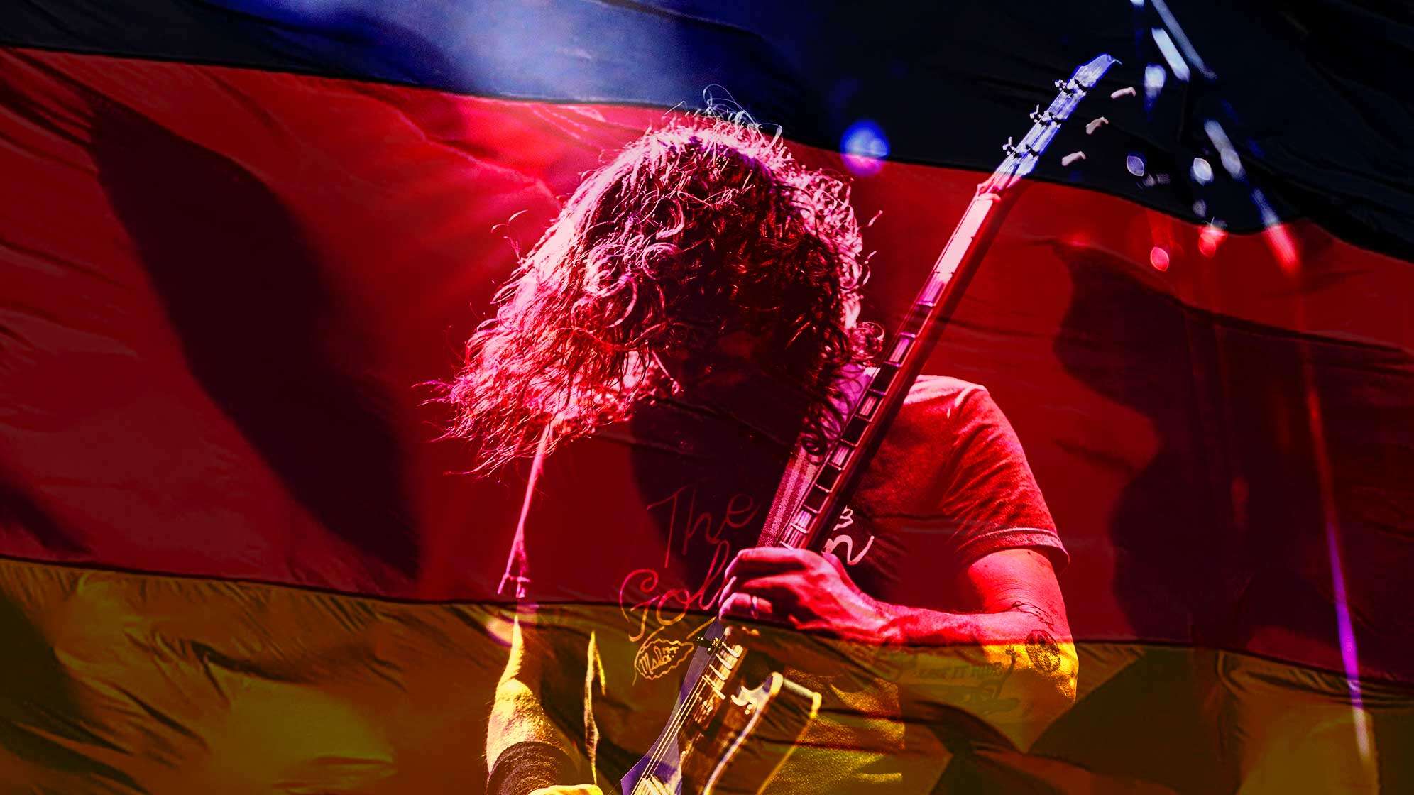 Ein Gitarrist performt vor einer Deutschland-Flagge.