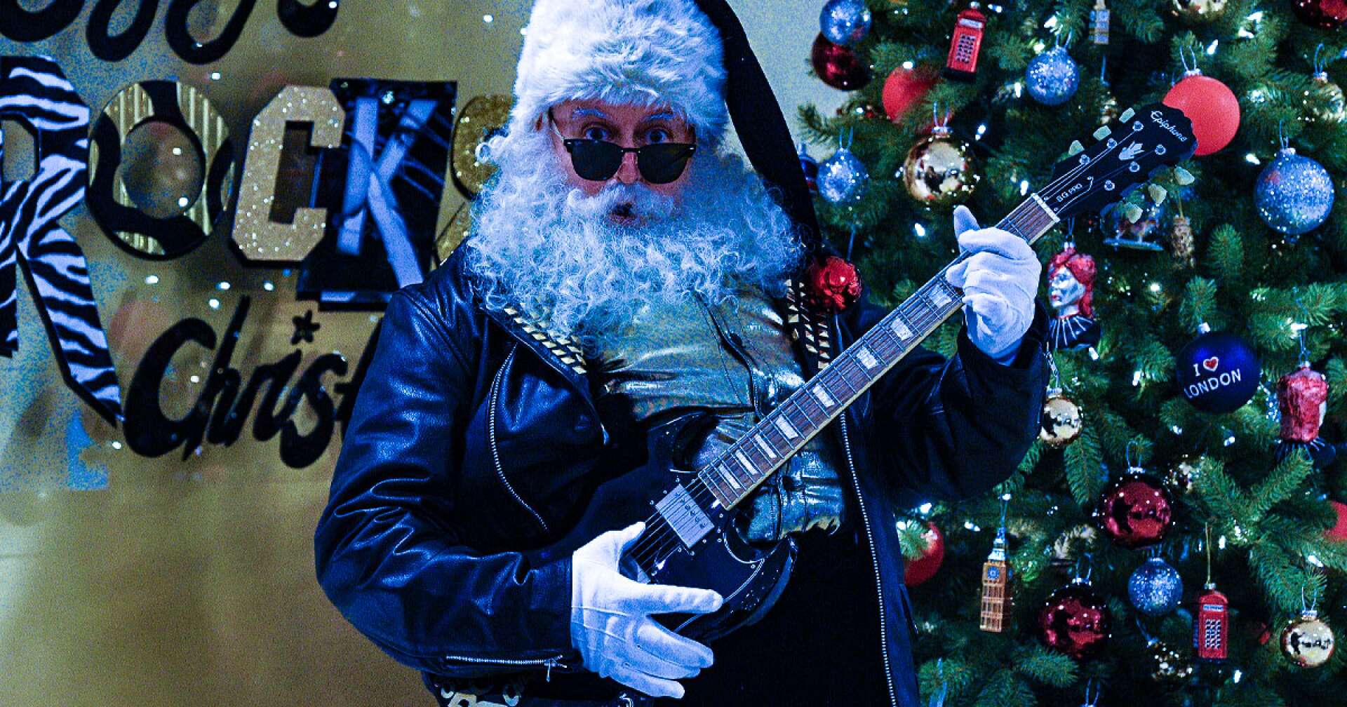 Ein Mann im Weihnachtsmann-Kostüm spielt Gitarre