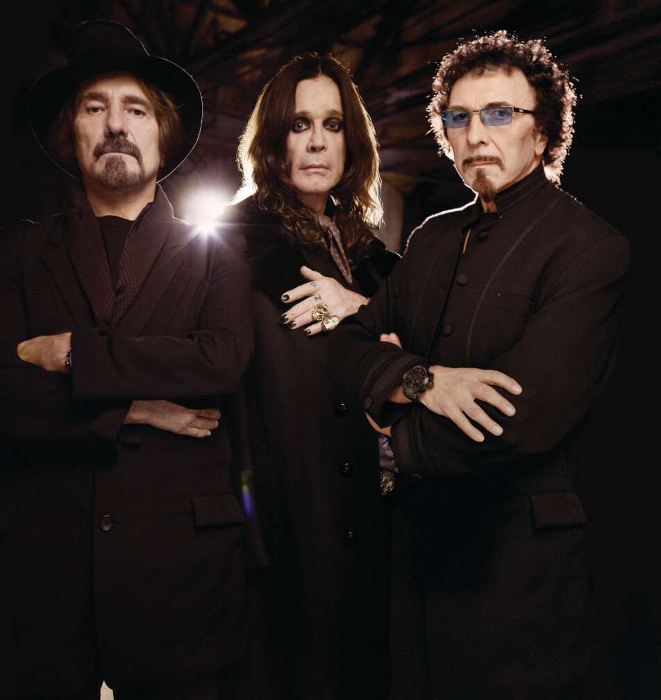 Black Sabbath mit verschränkten Armen vor einem schwarzen Hintergrund