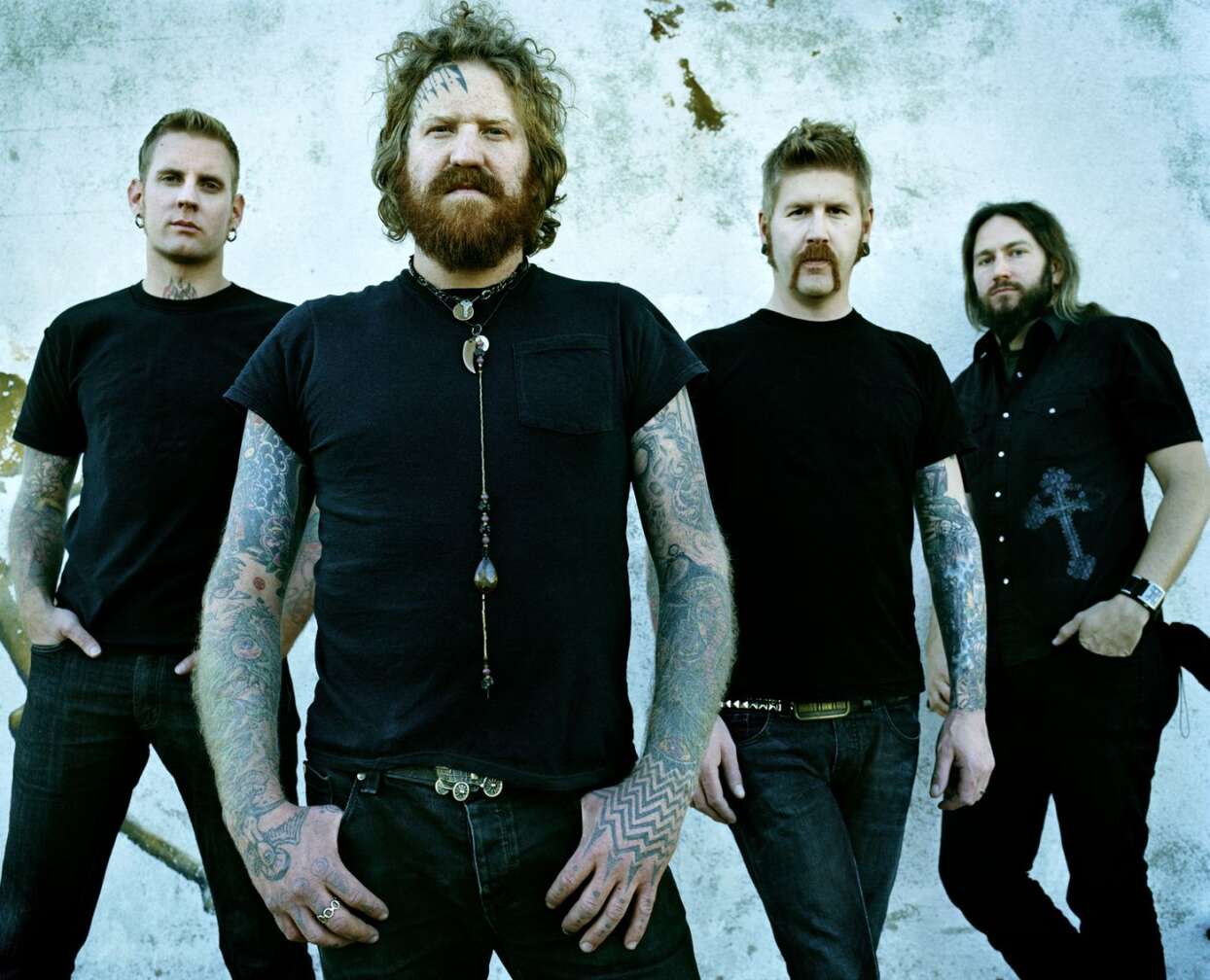 Mastodon als gruppe vor einem blauen Hintergrund in die Kamera schauend