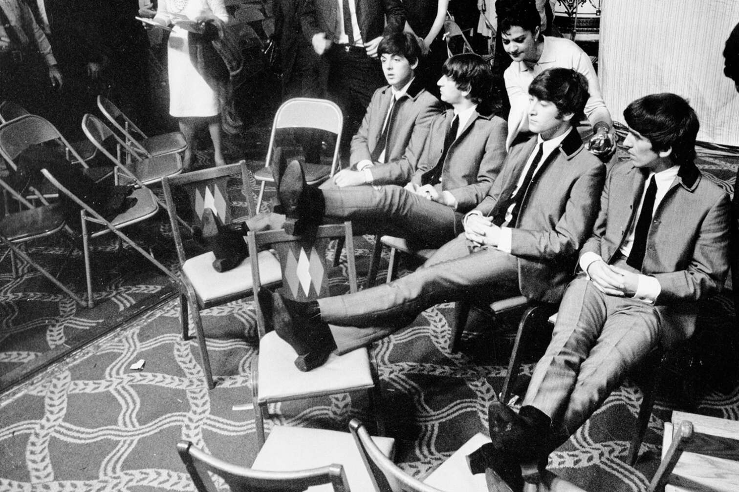 Die Beatles sitzen backstage und legen ihre Füße hoch