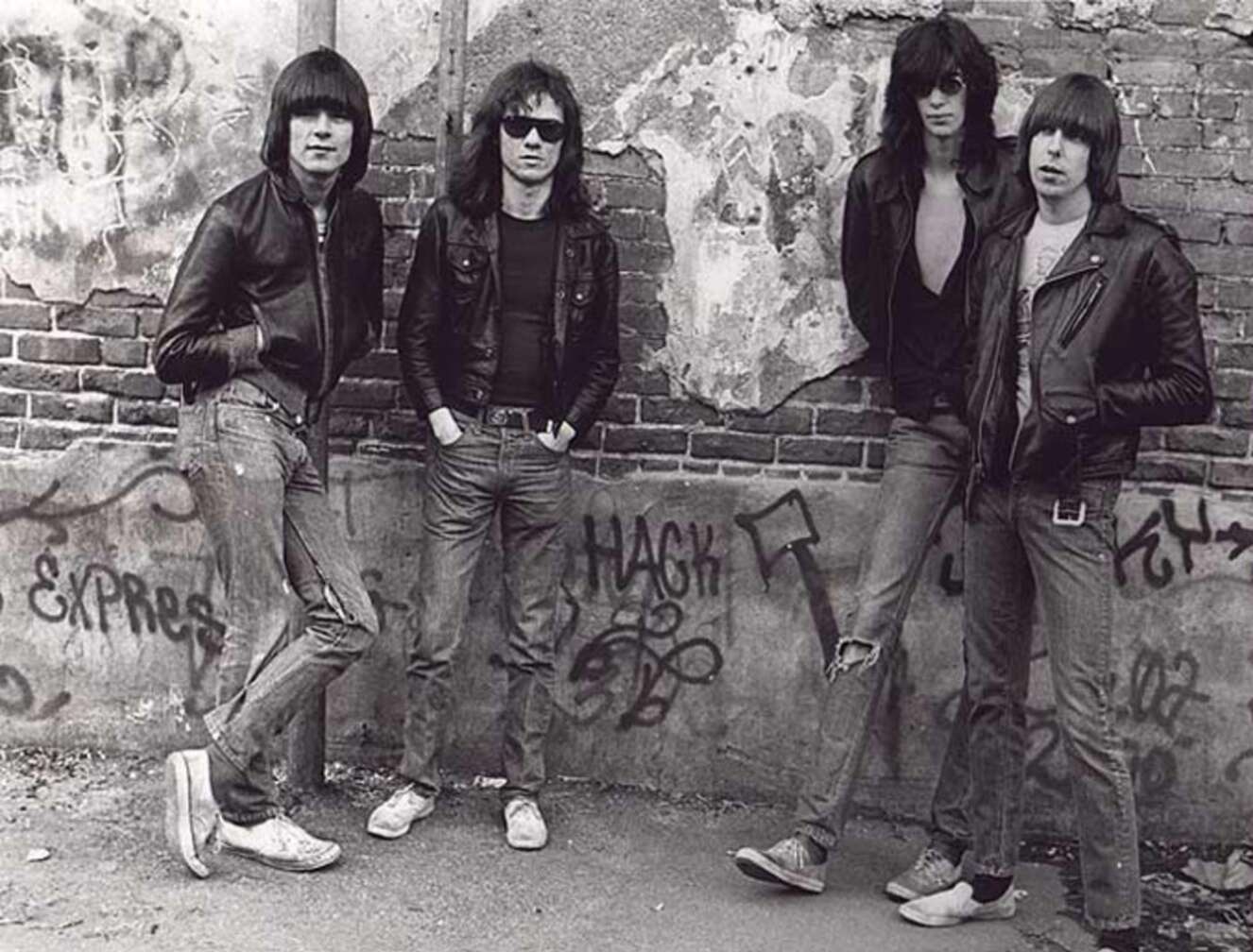 Ramones vor einer Wand mit vielen Grafittis mit Lederjacken