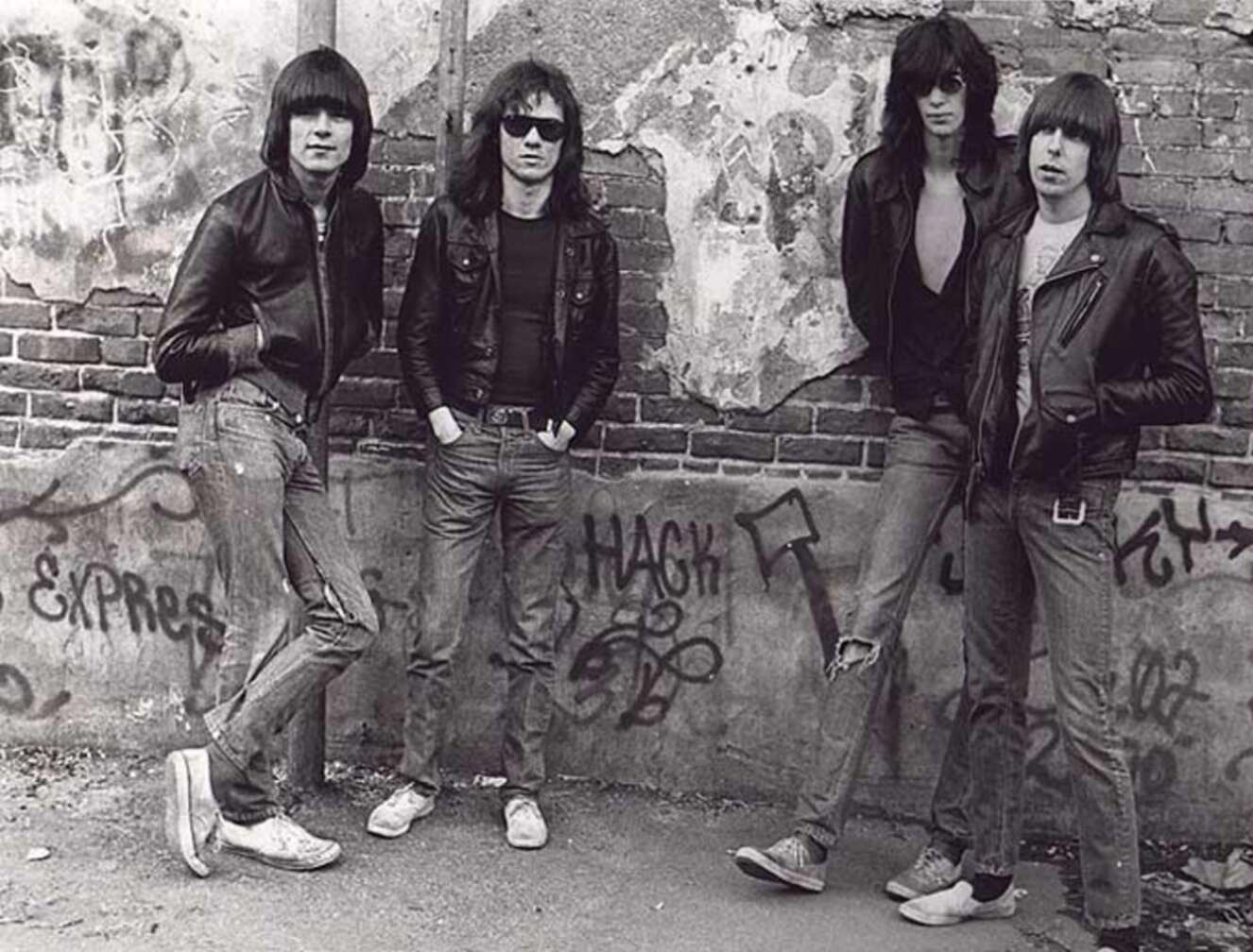 Ramones vor einer Wand mit vielen Grafittis mit Lederjacken