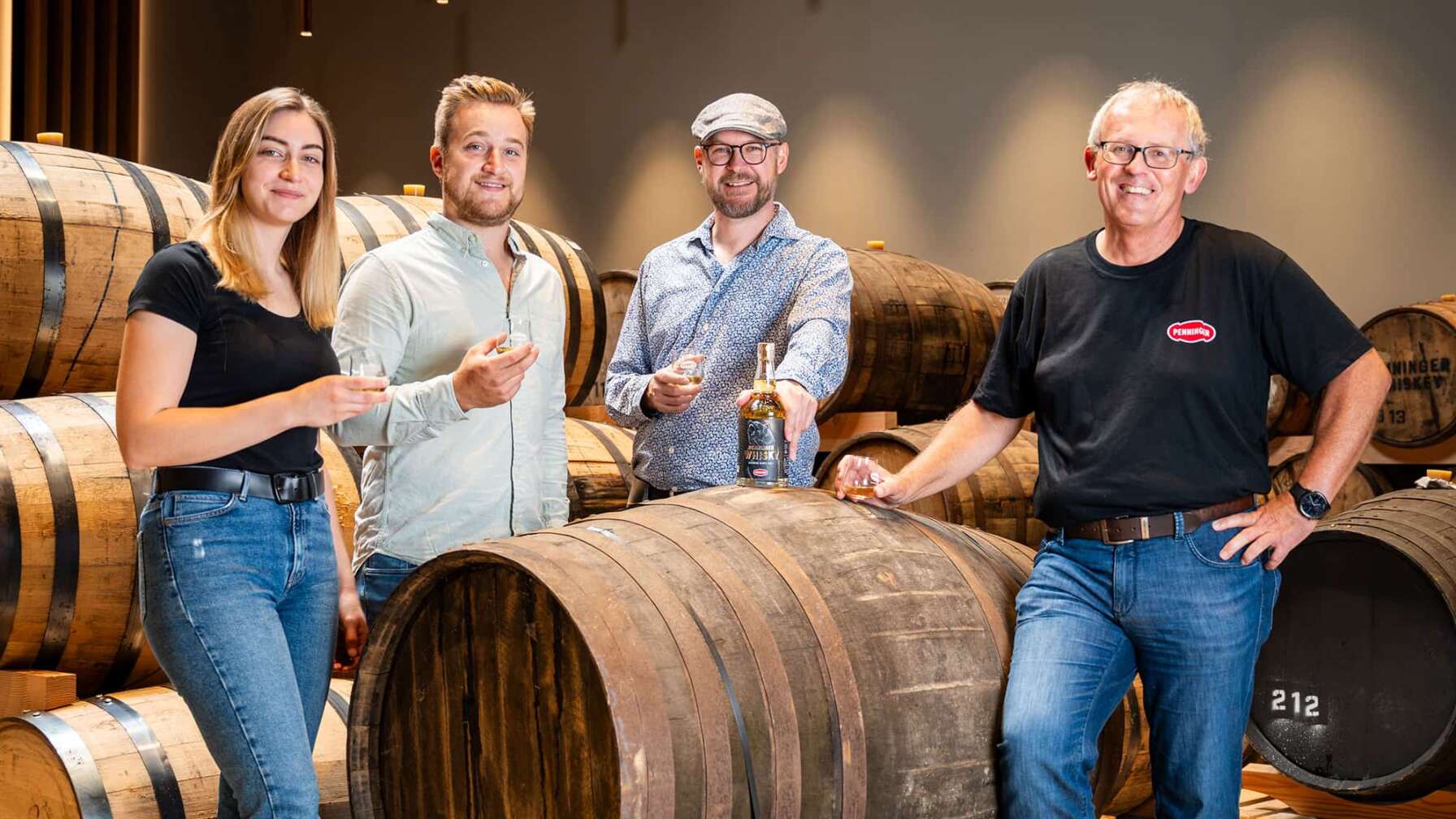 Bild des Penninger Whiskeys mit Whiskeyfass und Penninger Team darum herum