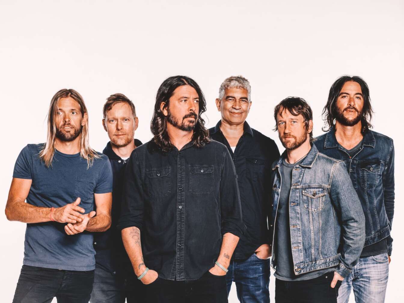 Die Foo Fighters stehen in einer Reihe für ein Bandfoto, blicken in verschiedene Richtungen, Fotomontage