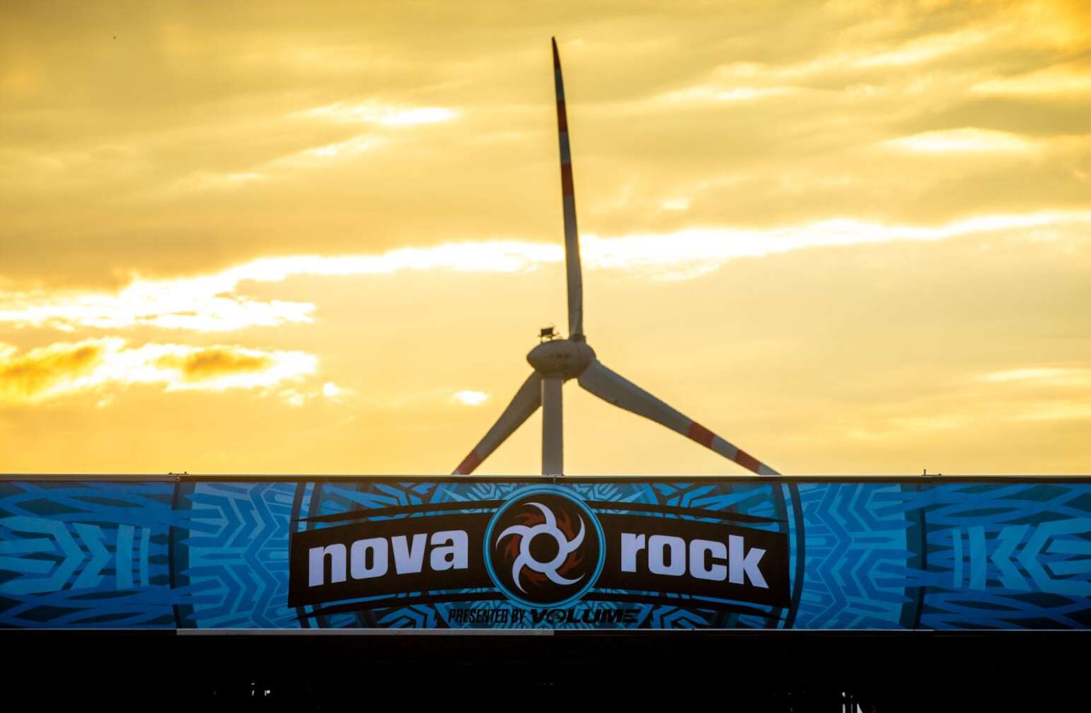 Nova Rock-Banner und Windrad im Hintergrund