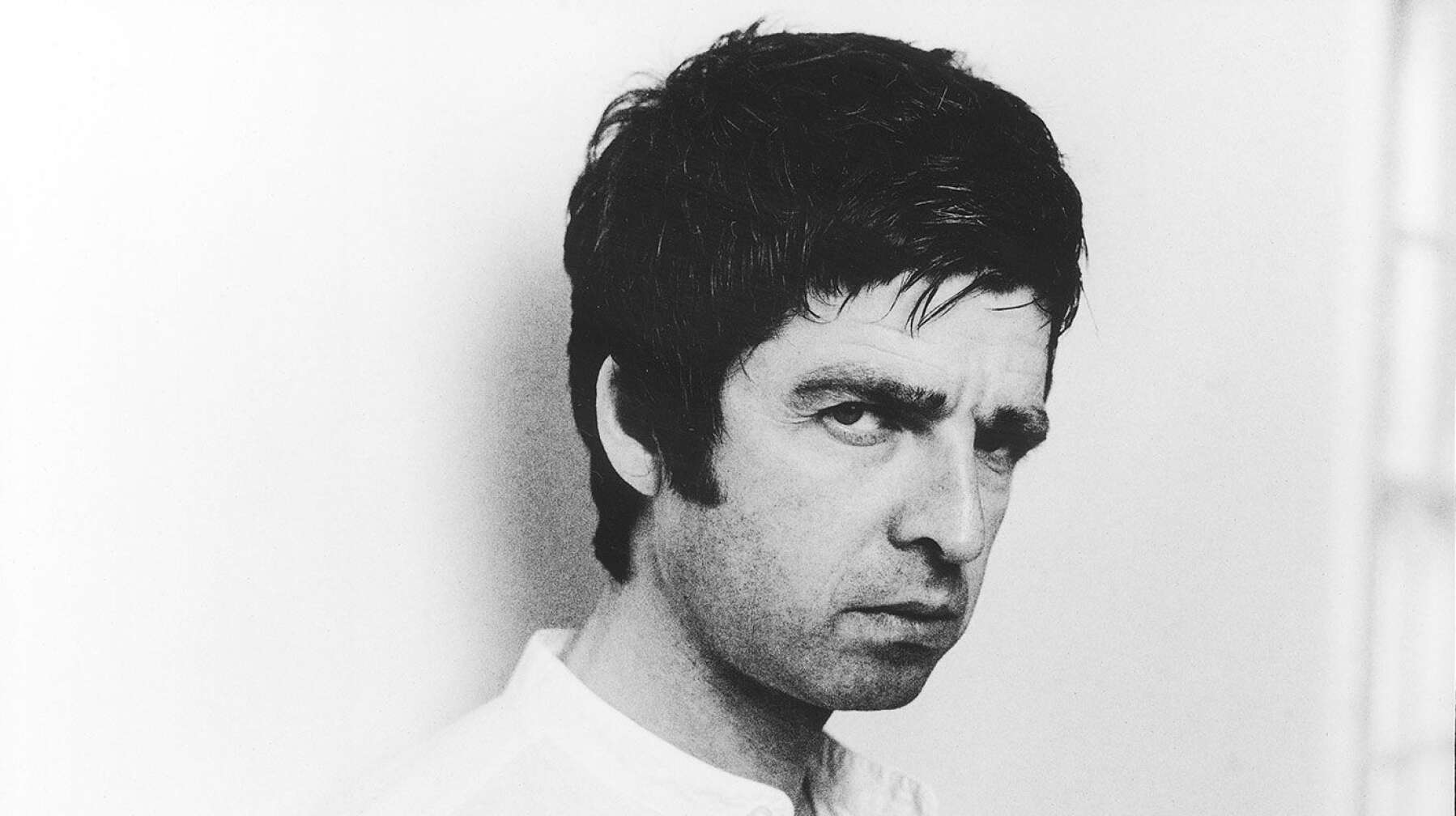 Noel Gallagher düster vor weißem Hintergrund
